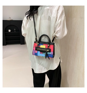 Detailed view of colorful geometric patchwork handbag with stylish tassel zipper pull