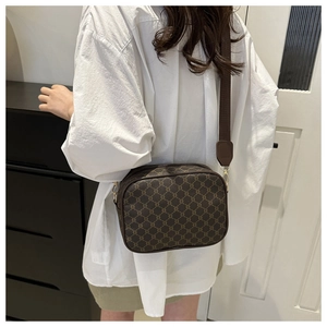 Brown monogram crossbody camera bag with wide fabric strap and golden hardware accents