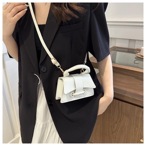 Close-up of white mini square handbag with lychee texture and golden hardware detail
