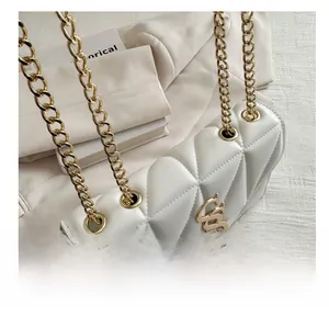 Detail of white quilted leather bag with gold SS logo, fringe, and metal eyelets