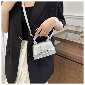 Detail of silver lychee texture on mini handbag with cross-body strap and top handle
