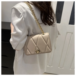 Vista posteriore di una borsa trapuntata beige con catena abbinata a un blazer bianco