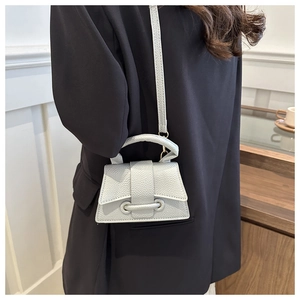Detail of silver lychee texture mini bag showing magnetic flap and metal ring decor