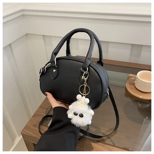 Détail du sac bowling en cuir PU noir avec charm monstre en peluche blanc et double anses