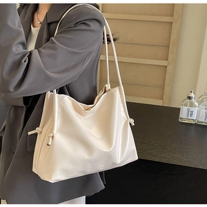 Detail of soft cream PU leather bucket bag featuring drawstring texture and dual straps