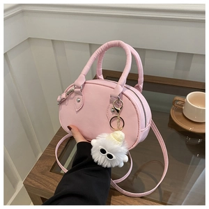 Détail d'un sac à main rose en cuir PU avec un joli porte-clés monstre en peluche