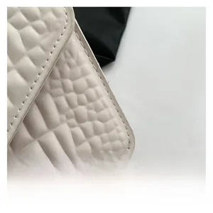 Détail du sac à rabat ivoire avec texture crocodile et coutures ton sur ton soignées