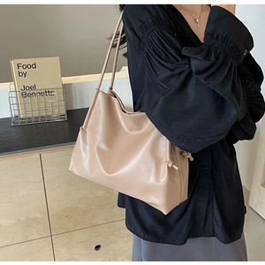 Detail of a beige soft PU leather hobo bucket bag featuring adjustable side drawstrings