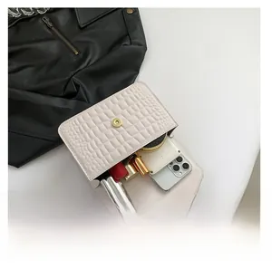 Vue détaillée du sac blanc motif crocodile montrant la capacité et le fermoir aimanté