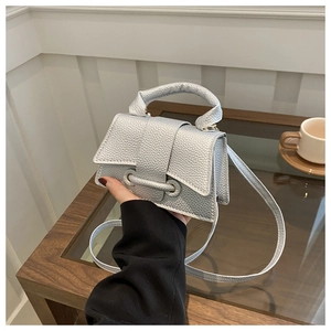 Detail of silver lychee pattern crossbody bag with metallic finish and top handle