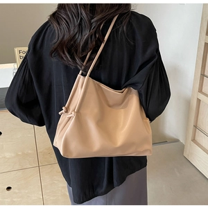 Close-up of soft PU leather bucket bag with braided knot detail and minimalist design
