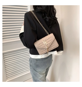 Détail du sac bandoulière motif pierre avec boucle SS dorée et décoration pompon