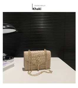 Détail du sac matelassé kaki avec logo SS doré, pompon et bandoulière chaîne en métal