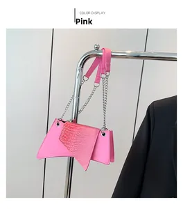 Detail of pink irregular leather shoulder bag with crocodile texture and silver chain