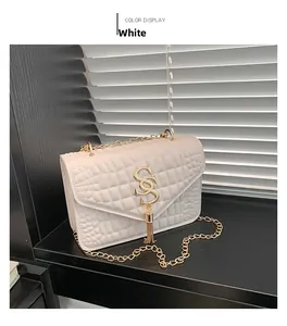 Détail du sac blanc gaufré avec bandoulière chaîne dorée et logo à pompon