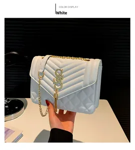 Detail der weißen Stepptasche mit goldener Quaste und Metall-Kettenriemen für Damen