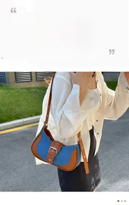 Detail of denim and brown leather patchwork shoulder bag with large retro buckle