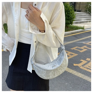 Silver crescent shoulder bag with white spiral embroidery and sleek metallic finish