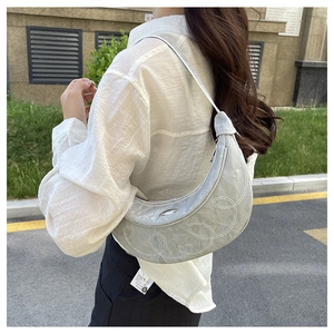 Detail of silver crescent saddle bag showing pleated texture and swirl embroidery
