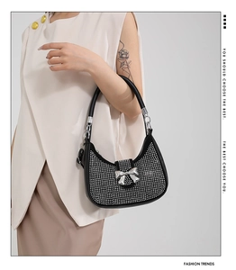 Detail of black rhinestone hobo bag featuring a sparkling silver mirror bow buckle