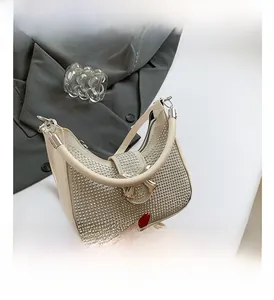Detailed view of cream rhinestone handbag featuring a metallic bow and elegant strap