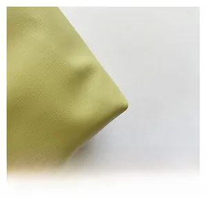 Detail shot of light green lychee textured faux leather with soft fashion pleats