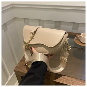 Détail du sac selle beige demi-lune avec bandoulière large et chaîne métallique dorée