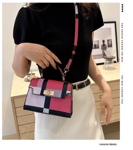 Detail showing the colorful plaid pattern, golden twist lock, and crossbody strap on the bag