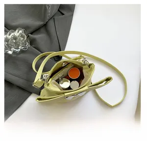 Top view showing the spacious interior of a green bow handbag holding a phone and lipstick