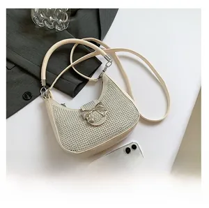 Detailed macro view of white rhinestone crescent bag featuring a metallic bow magnetic clasp