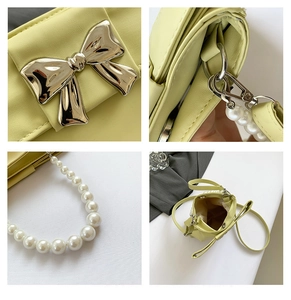 Detailed view of yellow pearl strap handbag with metallic bow accent and internal pocket