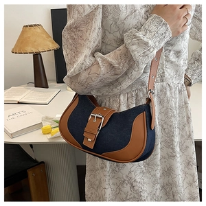 Detail of vintage denim and leather shoulder bag with metallic buckle and adjustable strap