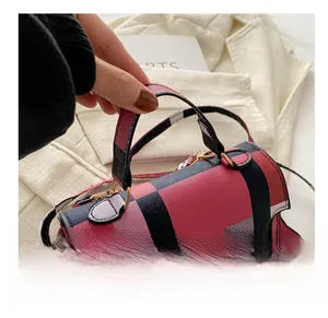 Detail view of colorful plaid mini handbag with gold hardware and textured cross pattern