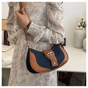 Detail of retro patchwork shoulder bag in blue denim and brown leather on model