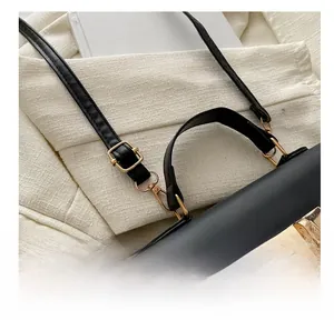 Detail of black PU handbag showing gold metal buckle and glitter texture decoration