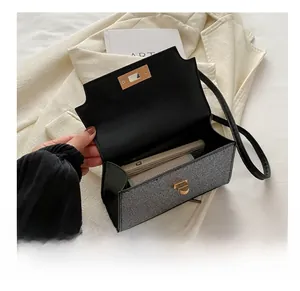 Detail view of the silver sequin bag interior capacity showing a phone and a card wallet