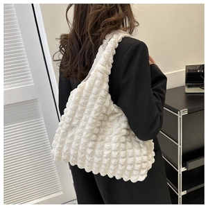 Close-up of the white bubble textured fabric and spacious design on a casual shoulder bag