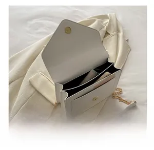Internal view of the white envelope bag showing main compartment and gold magnetic clasp