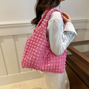 Detail of hot pink bubble textured tote bag with spacious interior and wide strap