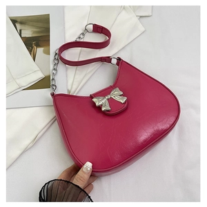 Macro shot of bright pink cracked leather texture and silver metal bow buckle detail