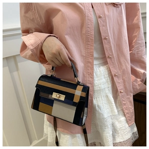Detailed view of color-block plaid crossbody bag with metal twist lock on model