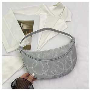 Detail of grey crescent shoulder bag with white heart stitching and wrinkled leather