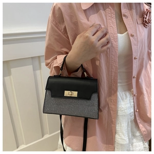 Detail of contrast handbag featuring black leather flap and grey sequin texture with gold lock
