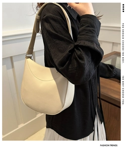 Detail of beige half-moon bag featuring premium lychee grain texture and wide strap