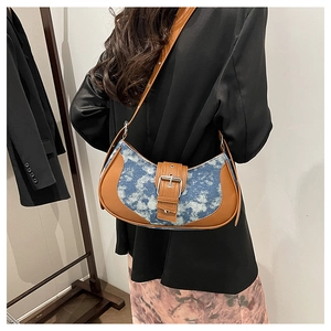 Retro patchwork denim saddle bag with brown leather trim and metal buckle closure
