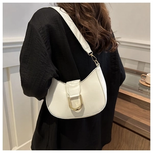 Dettaglio borsa hobo bianca a mezzaluna con fibbia dorata indossata a spalla