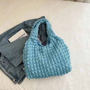 Detail of light blue popcorn texture shoulder bag with soft cloud fabric wrinkles