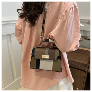 Detail of color-block crossbody bag with geometric panels and gold metallic turn-lock