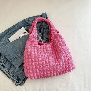 Detail of pink bubble texture hobo bag on a casual background with denim jacket