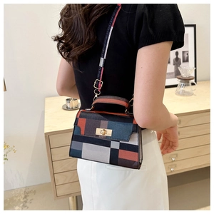 Detail of a vintage geometric plaid crossbody bag showing hardware and strap on a model
